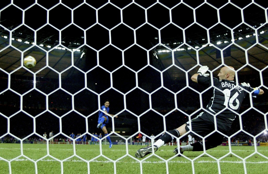 BERLIN - JULY 09: Fabio Grosso (L) of Italy takes the matchwinning penalty, as Goalkeeper Fabien Barthez (R) of France dives the wrong way during the FIFA World Cup Germany 2006 Final match between Italy and France at the Olympic Stadium on July 9, 2006 in Berlin, Germany. (Photo by Michael Steele/Getty Images)